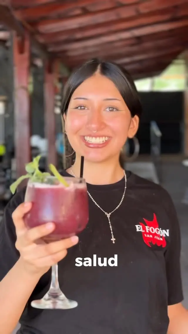 Garzona brindando con un trago de frutos rojos